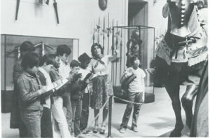 Barbara Pollard and a group of children in the Arts & Armor Gallery. junior museum