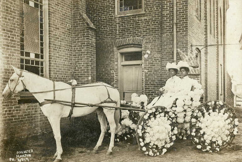 Martha Yates Jones (left) and Pinkie Yates (right), daughters of Rev. Jack Yates, in a decorated carriage parked in front of the Antioch Baptist Church located in Houston's Fourth Ward, 1908